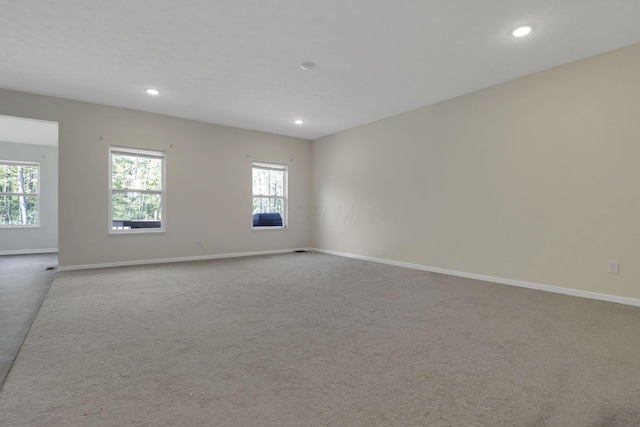 carpeted empty room featuring baseboards and recessed lighting