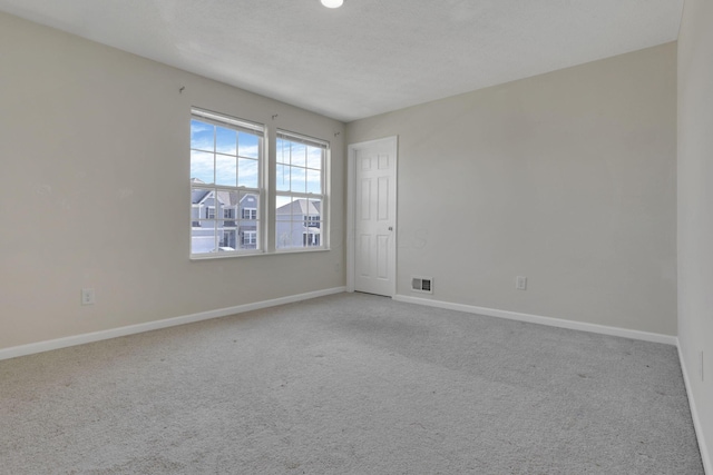 carpeted empty room with baseboards and visible vents