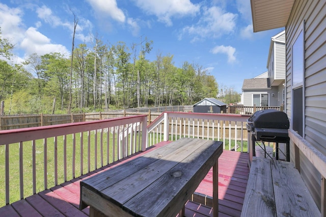 wooden deck featuring a fenced backyard, a lawn, and area for grilling