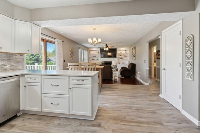 81 Highmeadows Cir, Powell, OH 43065 - kitchen featuring stainless steel dishwasher, light countertops, white cabinets, a notable chandelier, and a peninsula