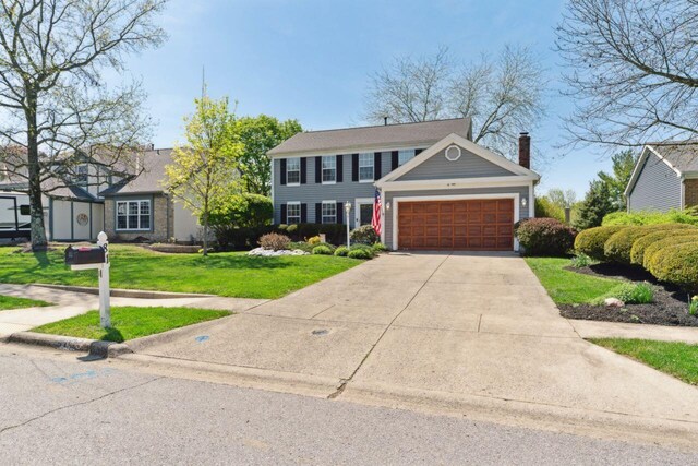 81 Highmeadows Cir, Powell, OH 43065 - view of front of house featuring a chimney, concrete driveway, a front yard, and a garage