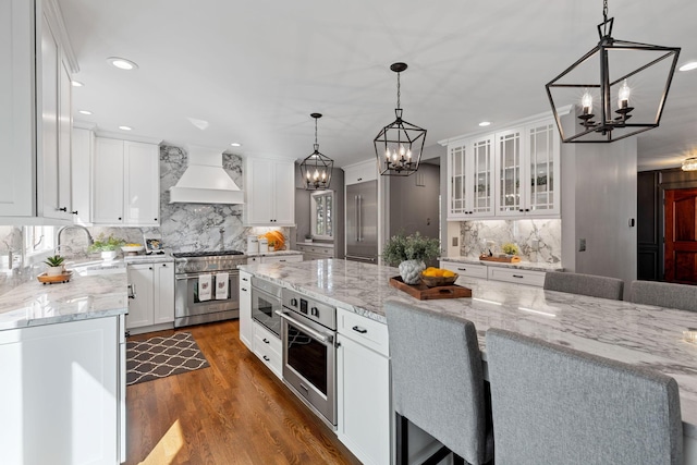 660 Woods Hollow Ln, Powell, OH 43065 - kitchen featuring a sink, high end appliances, premium range hood, and a notable chandelier