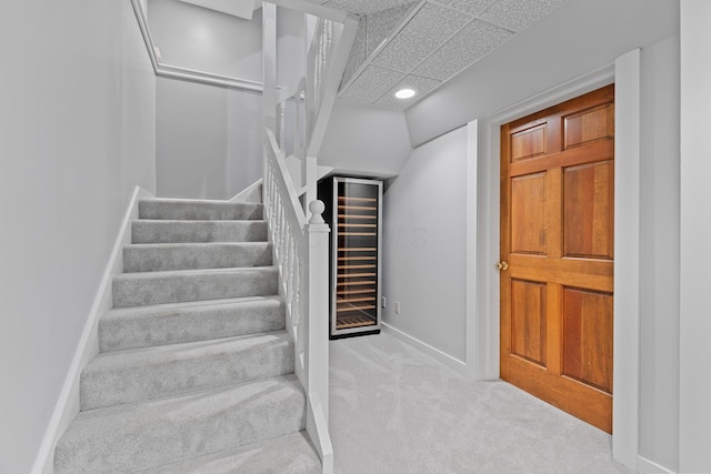 660 Woods Hollow Ln, Powell, OH 43065 - stairs featuring beverage cooler, recessed lighting, carpet, baseboards, and a paneled ceiling