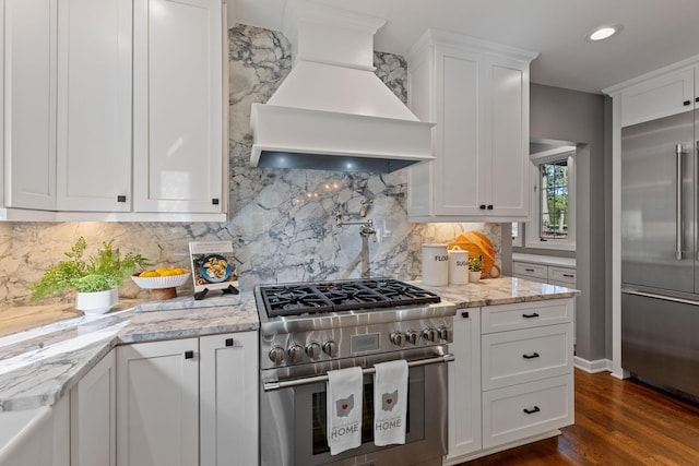 660 Woods Hollow Ln, Powell, OH 43065 - kitchen featuring white cabinetry, decorative backsplash, premium range hood, dark wood-style floors, and high quality appliances