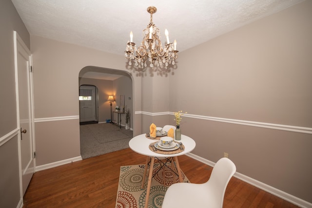 264 Merchant Ave, Marion, OH 43302 - dining area featuring wood finished floors, baseboards, a textured ceiling, a chandelier, and arched walkways