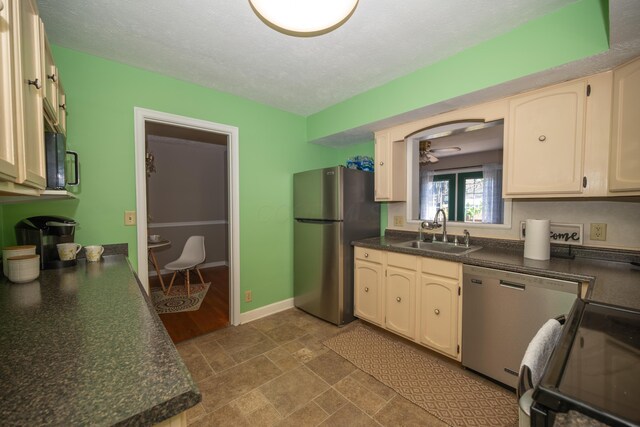 264 Merchant Ave, Marion, OH 43302 - kitchen featuring stone finish floor, appliances with stainless steel finishes, dark countertops, a sink, and baseboards