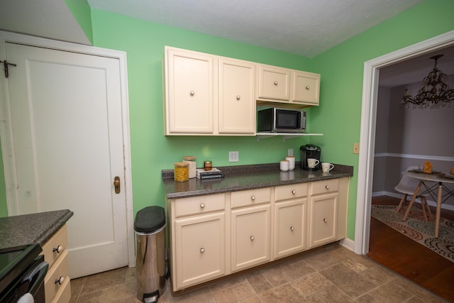 264 Merchant Ave, Marion, OH 43302 - kitchen featuring an inviting chandelier, dark countertops, and range