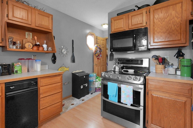 kitchen featuring light countertops, range with two ovens, black microwave, and light wood-style floors