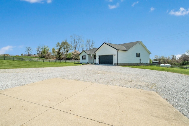 view of property exterior featuring a lawn, gravel driveway, an attached garage, and fence