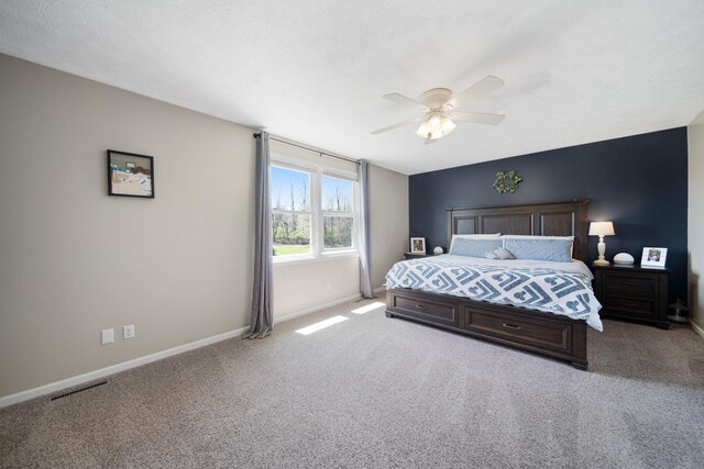 bedroom with baseboards, visible vents, ceiling fan, and carpet