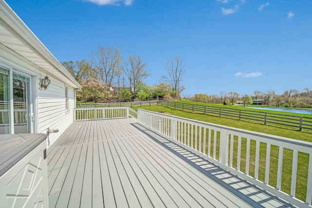wooden deck with a lawn, a water view, and a fenced backyard