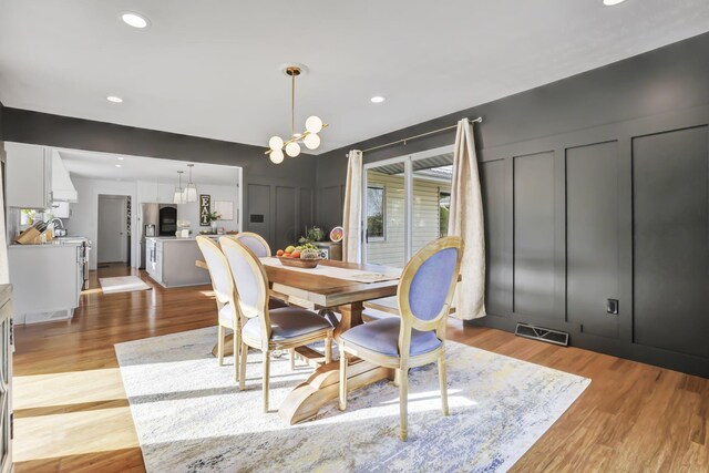 6495 Julian Rd SW, Amanda, OH 43102 - dining room with a decorative wall, a notable chandelier, visible vents, and light wood-style floors