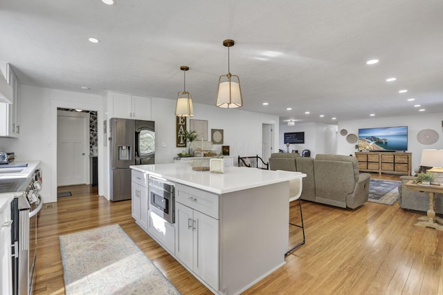 6495 Julian Rd SW, Amanda, OH 43102 - kitchen with light countertops, white cabinetry, appliances with stainless steel finishes, and a breakfast bar