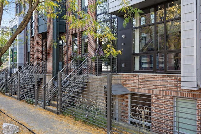 view of home's exterior with brick siding and stairs