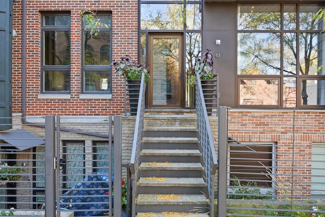 property entrance with brick siding and fence