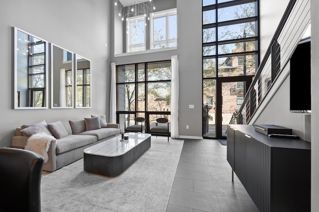 living room featuring an inviting chandelier, tile patterned floors, and a high ceiling