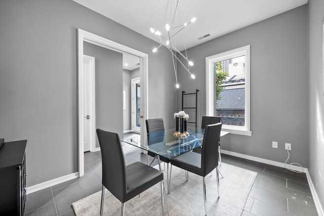 tiled dining space with a chandelier, baseboards, and visible vents