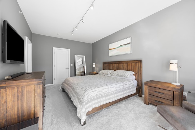 bedroom featuring rail lighting and light colored carpet