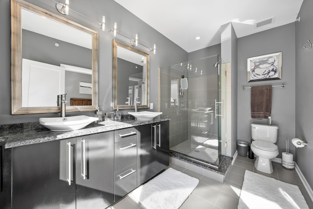 full bath featuring a sink, tile patterned floors, a shower stall, and toilet