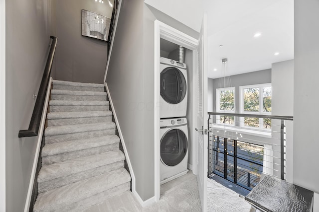 clothes washing area with laundry area, recessed lighting, baseboards, and stacked washing maching and dryer