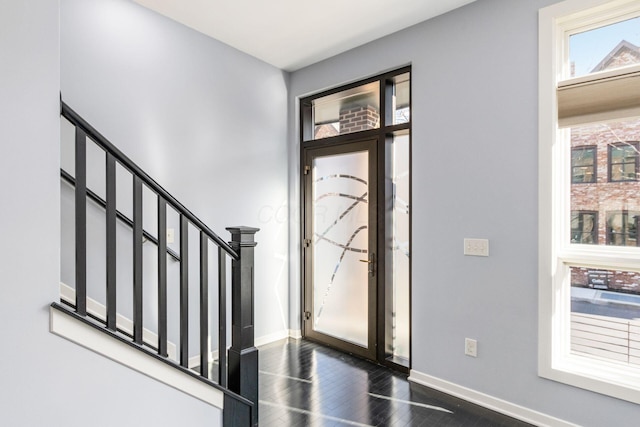 entryway with stairs, baseboards, and dark wood finished floors