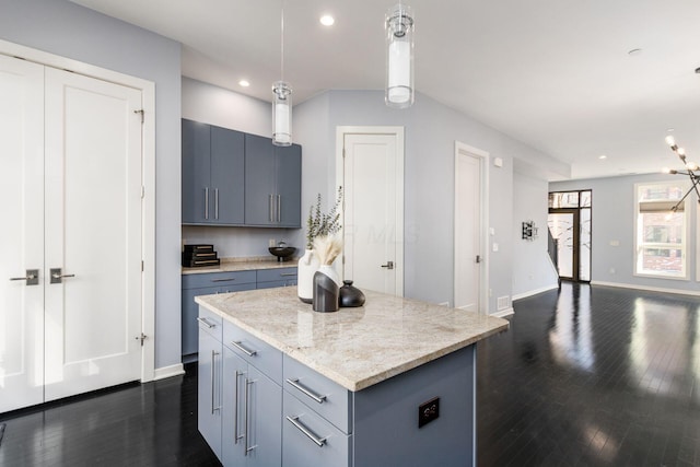 kitchen featuring pendant lighting, a center island, recessed lighting, dark wood finished floors, and gray cabinetry