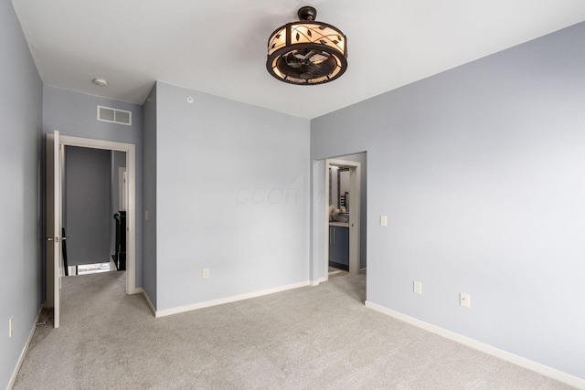 unfurnished bedroom with baseboards, carpet, and visible vents