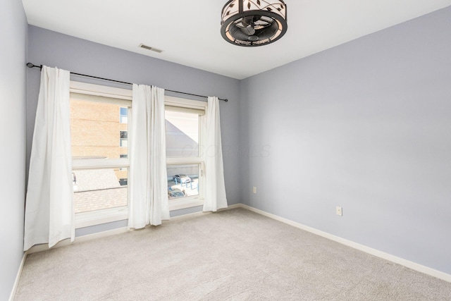 carpeted empty room with baseboards and visible vents