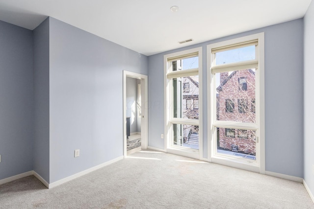 empty room with visible vents, carpet flooring, and baseboards