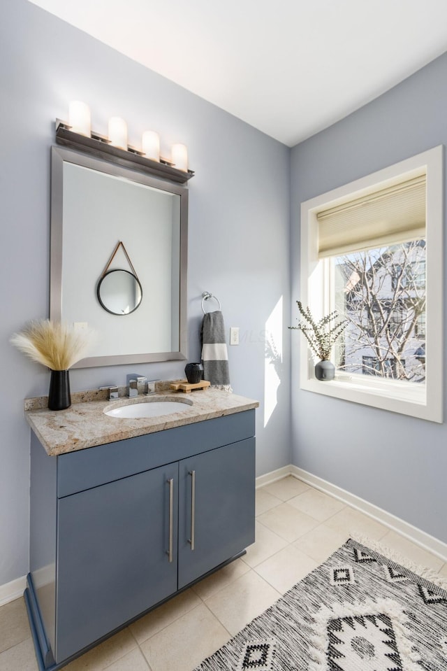 bathroom with vanity, baseboards, and tile patterned flooring