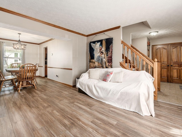 6008 Macnabb Ct, Hilliard, OH 43026 - living area featuring a textured ceiling, a notable chandelier, stairway, and light wood-type flooring