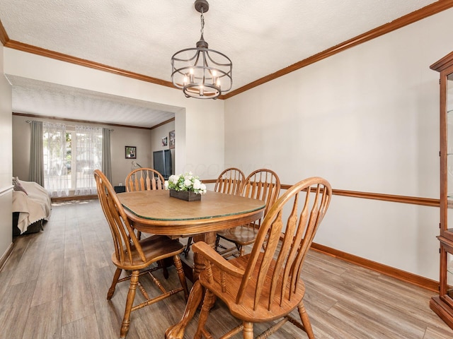 6008 Macnabb Ct, Hilliard, OH 43026 - dining area with ornamental molding, light wood-style floors, baseboards, a textured ceiling, and a chandelier
