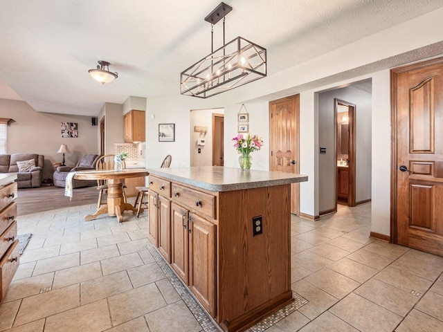6008 Macnabb Ct, Hilliard, OH 43026 - kitchen featuring a kitchen island, decorative light fixtures, tasteful backsplash, light tile patterned floors, and open floor plan