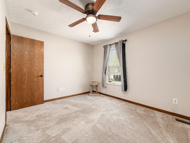 6008 Macnabb Ct, Hilliard, OH 43026 - carpeted spare room with visible vents, a textured ceiling, baseboards, and ceiling fan