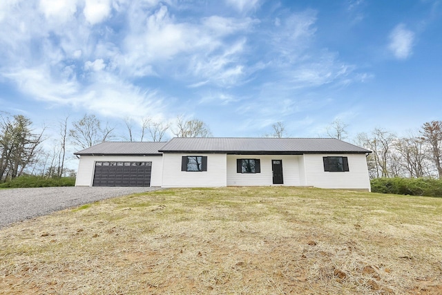 view of front of home with driveway, metal roof, a front yard, and a garage