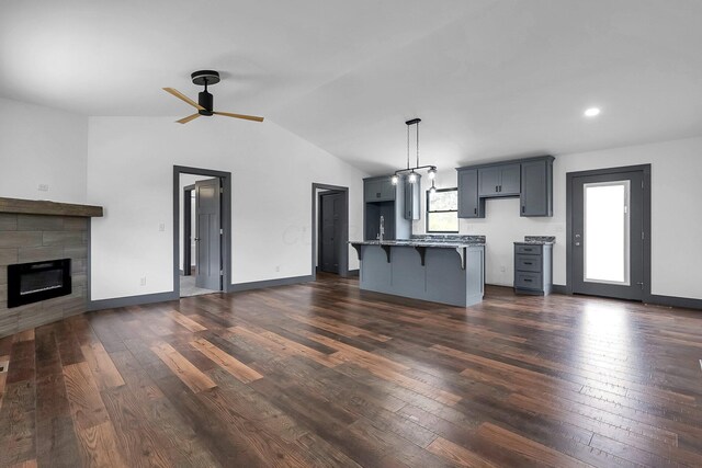 kitchen with dark wood-style floors, a kitchen breakfast bar, ceiling fan, and open floor plan