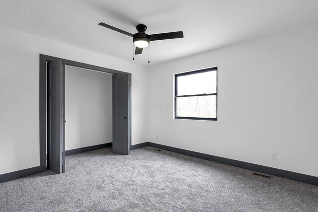 unfurnished bedroom with a ceiling fan, visible vents, carpet, and baseboards