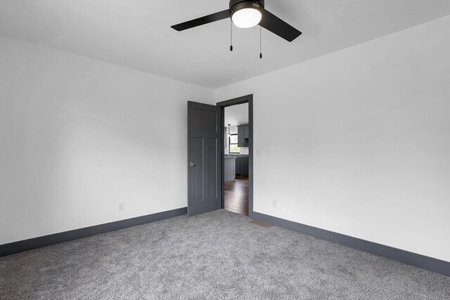 spare room featuring a ceiling fan, carpet floors, and baseboards