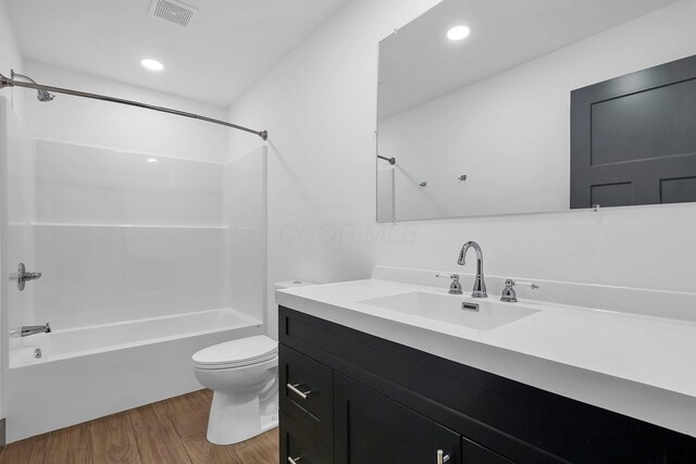 full bath featuring visible vents, tub / shower combination, toilet, wood finished floors, and vanity