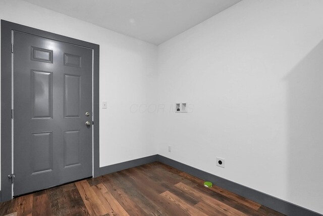 empty room with baseboards and dark wood-type flooring