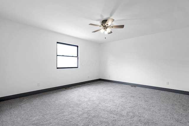 unfurnished room featuring carpet floors, ceiling fan, and baseboards