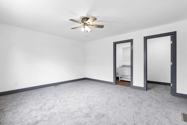 unfurnished bedroom featuring ensuite bathroom, baseboards, and carpet floors