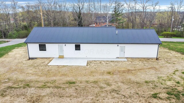rear view of property featuring metal roof and a patio area