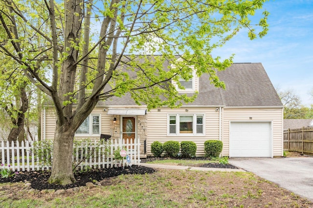 view of front of home featuring fence, aphalt driveway, a shingled roof, and an attached garage