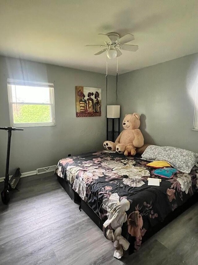 bedroom featuring ceiling fan, wood finished floors, and baseboards