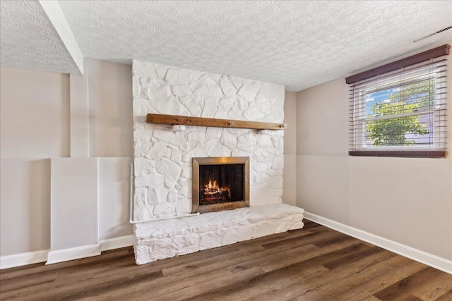 4096 Jonquil St, Columbus, OH 43224 - interior space featuring a textured ceiling, baseboards, a stone fireplace, and wood finished floors