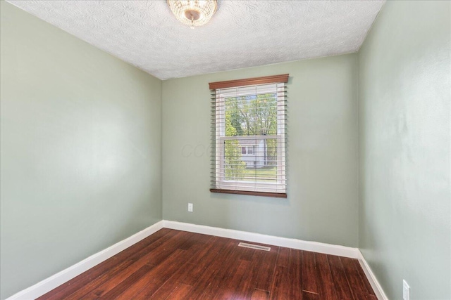 4096 Jonquil St, Columbus, OH 43224 - unfurnished room featuring baseboards, visible vents, a textured ceiling, and dark wood-type flooring