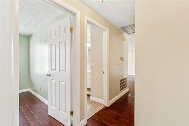 4096 Jonquil St, Columbus, OH 43224 - hall with wood-type flooring, a textured ceiling, visible vents, and baseboards