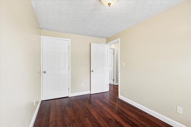 4096 Jonquil St, Columbus, OH 43224 - unfurnished bedroom featuring baseboards, a textured ceiling, and dark wood finished floors