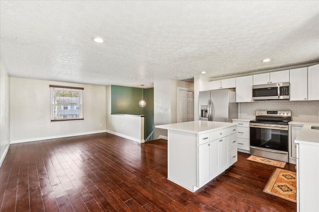 4096 Jonquil St, Columbus, OH 43224 - kitchen featuring stainless steel appliances, baseboards, a textured ceiling, and a center island